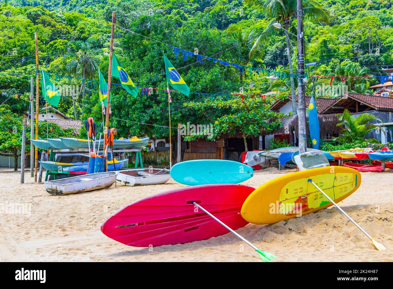 Tavole da surf colorate con bandiera brasiliana presso la splendida spiaggia di Mangrove e Pooso sulla grande isola tropicale Ilha Grande Rio de Janeiro Brasile. Foto Stock