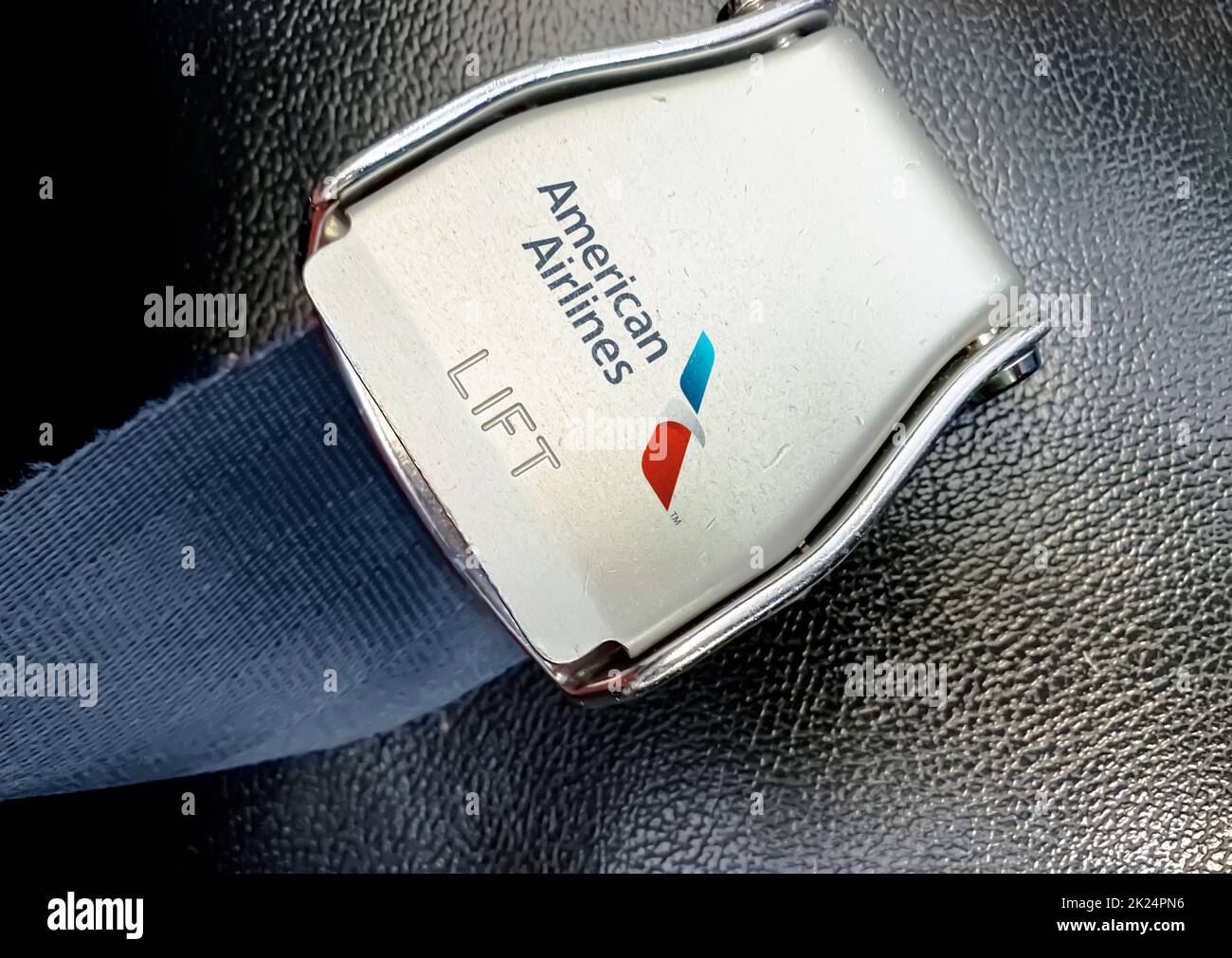 New York, USA, luglio 2020: Cintura di un sedile vuoto all'interno di un aereo con il logo American Airlines stampato sul metallo. Sicurezza dei viaggi e dell'aeroporto Foto Stock