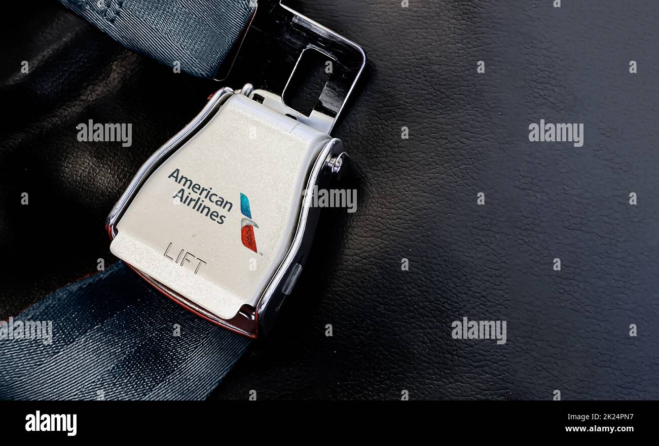 New York, USA, luglio 2020: Cintura di un sedile vuoto all'interno di un aereo con il logo American Airlines stampato sul metallo. Sicurezza dei viaggi e dell'aeroporto Foto Stock
