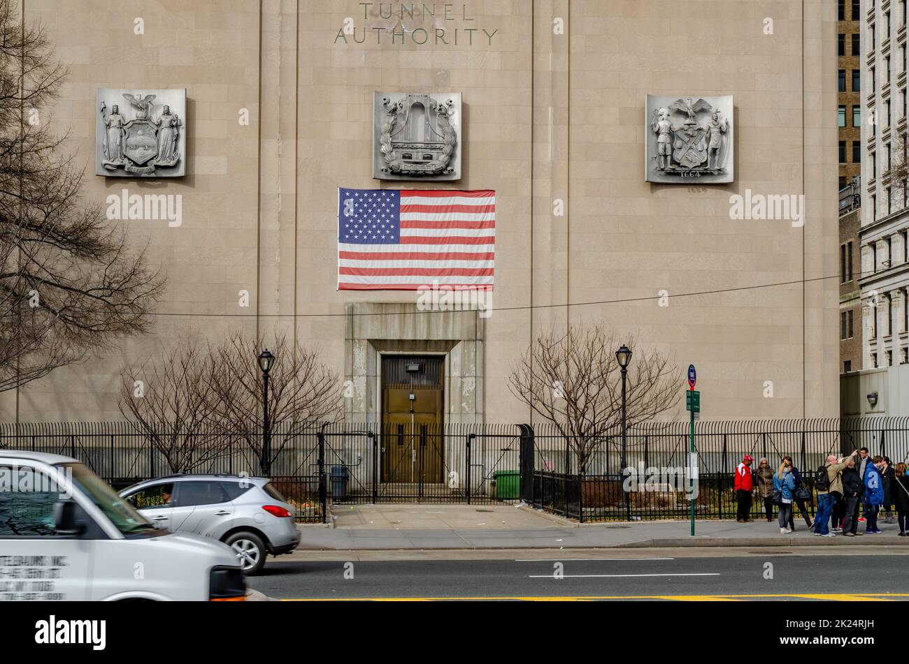 New York City Triborough Bridge e Tunnel Authority Building con ingresso dell'edificio e bandiera americana sulla parte superiore, strada con traffico e a piedi p Foto Stock