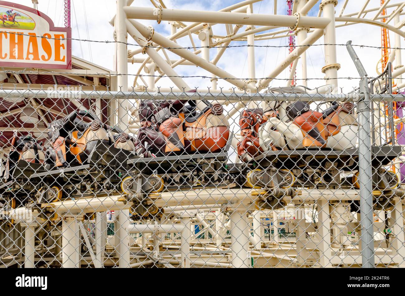 Le montagne russe Steeplechase sono chiuse, vuote al Luna Park Amusement Park con recinzione di fronte, Coney Island, Brooklyn, New York City durante la giornata invernale con nuvole Foto Stock