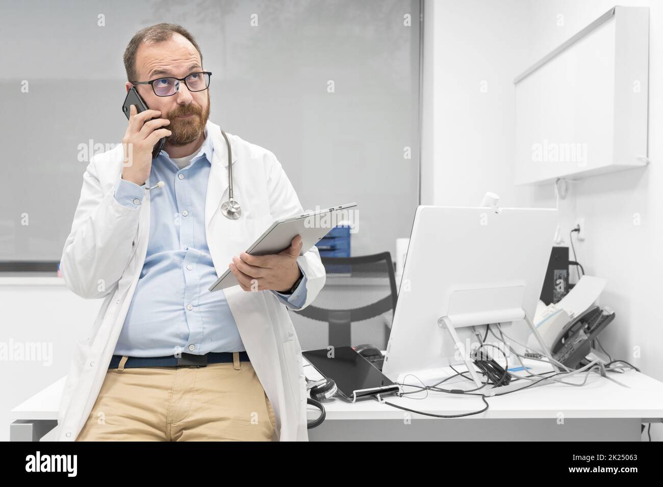 Medico maschile premuroso utilizzando tablet digitale pensando alla soluzione del problema medico. Fotografia di alta qualità Foto Stock