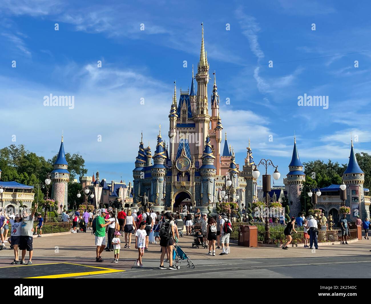 Bay Lake, FL USA - 14 settembre 2022: Vista su strada dei turisti che camminano lungo la strada principale USA al magico parco del regno con il castello di cenerentola Foto Stock