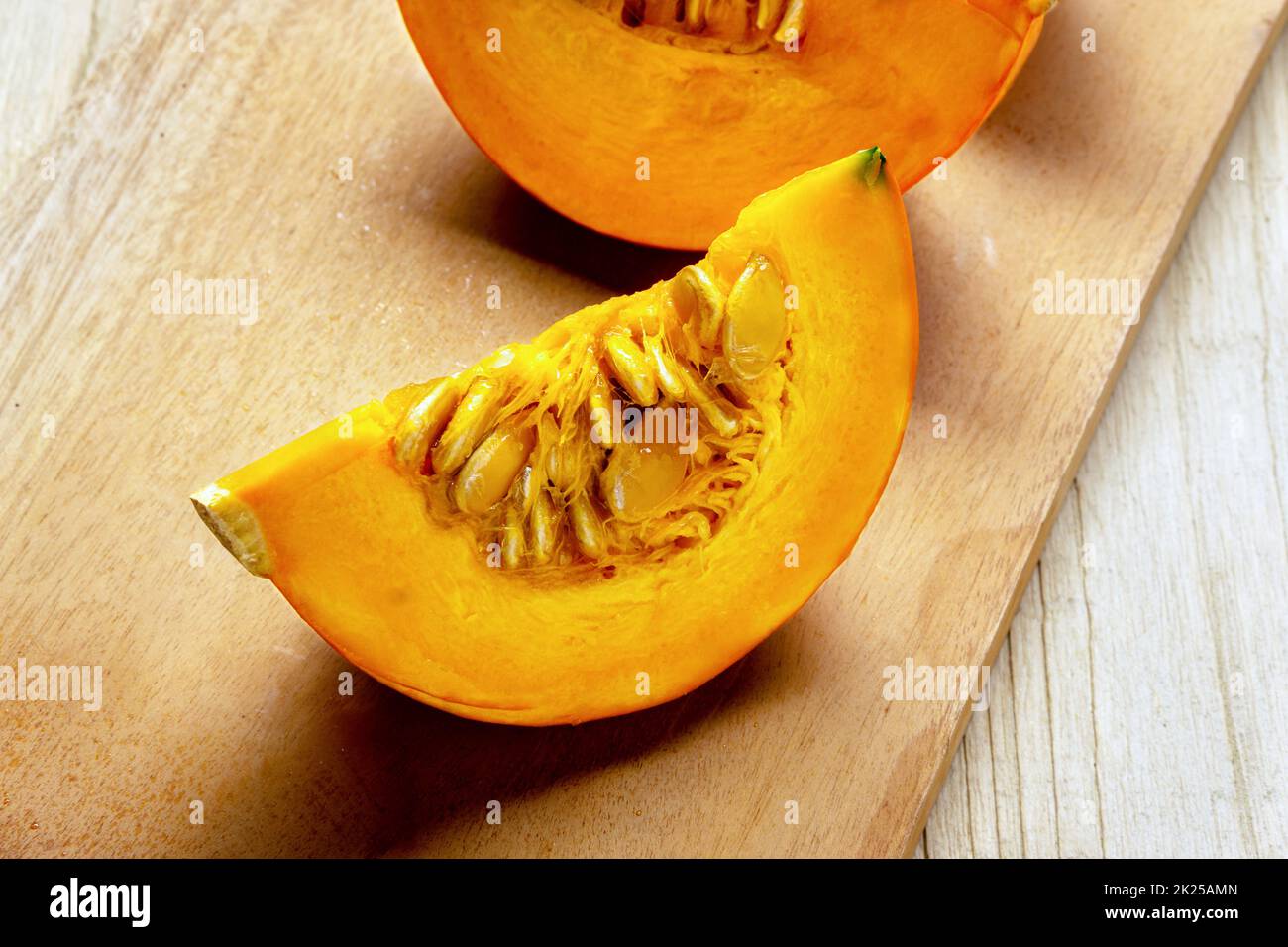 Fette di zucca gialla sul tagliere. Schiaccia fresca tagliata su tavola di legno. Stagionale, raccolto, autunno, autunno, cibo biologico. Posiziona per testo. Foto Stock