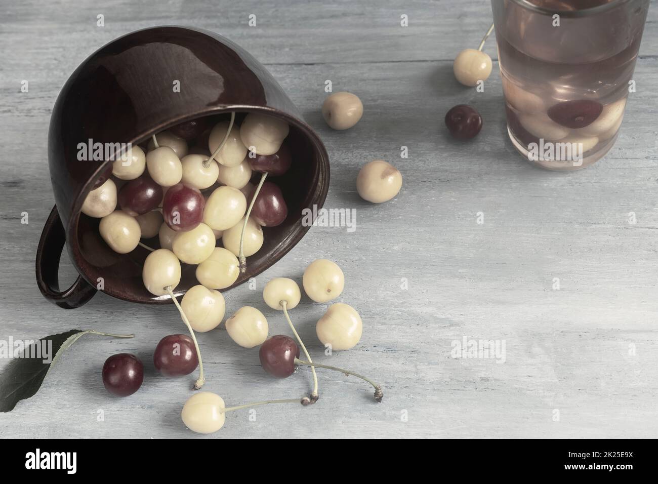 Ciliegie gialle e rosse in una tazza di ceramica Foto Stock