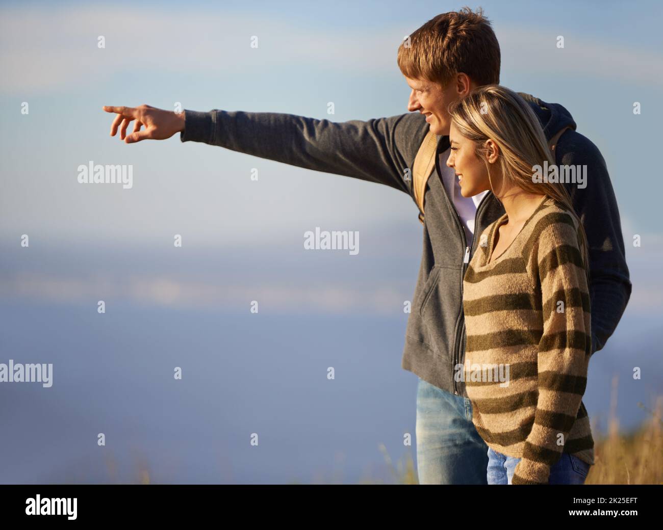 Check that out. Un bel giovane uomo che indica qualcosa per la sua ragazza di vedere durante un'escursione. Foto Stock