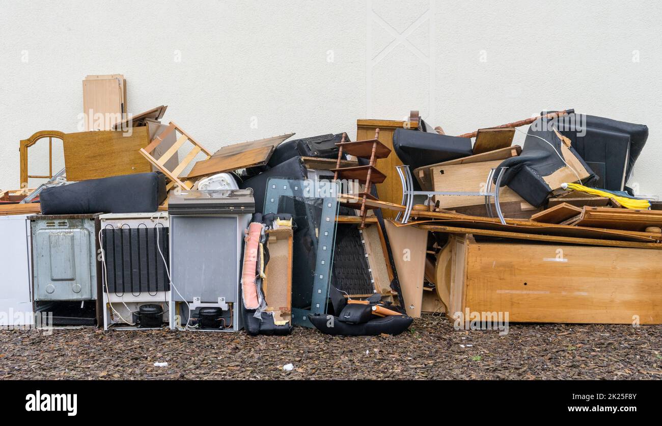 Mucchio ingombrante di rifiuti di fronte ad un muro di casa Foto Stock