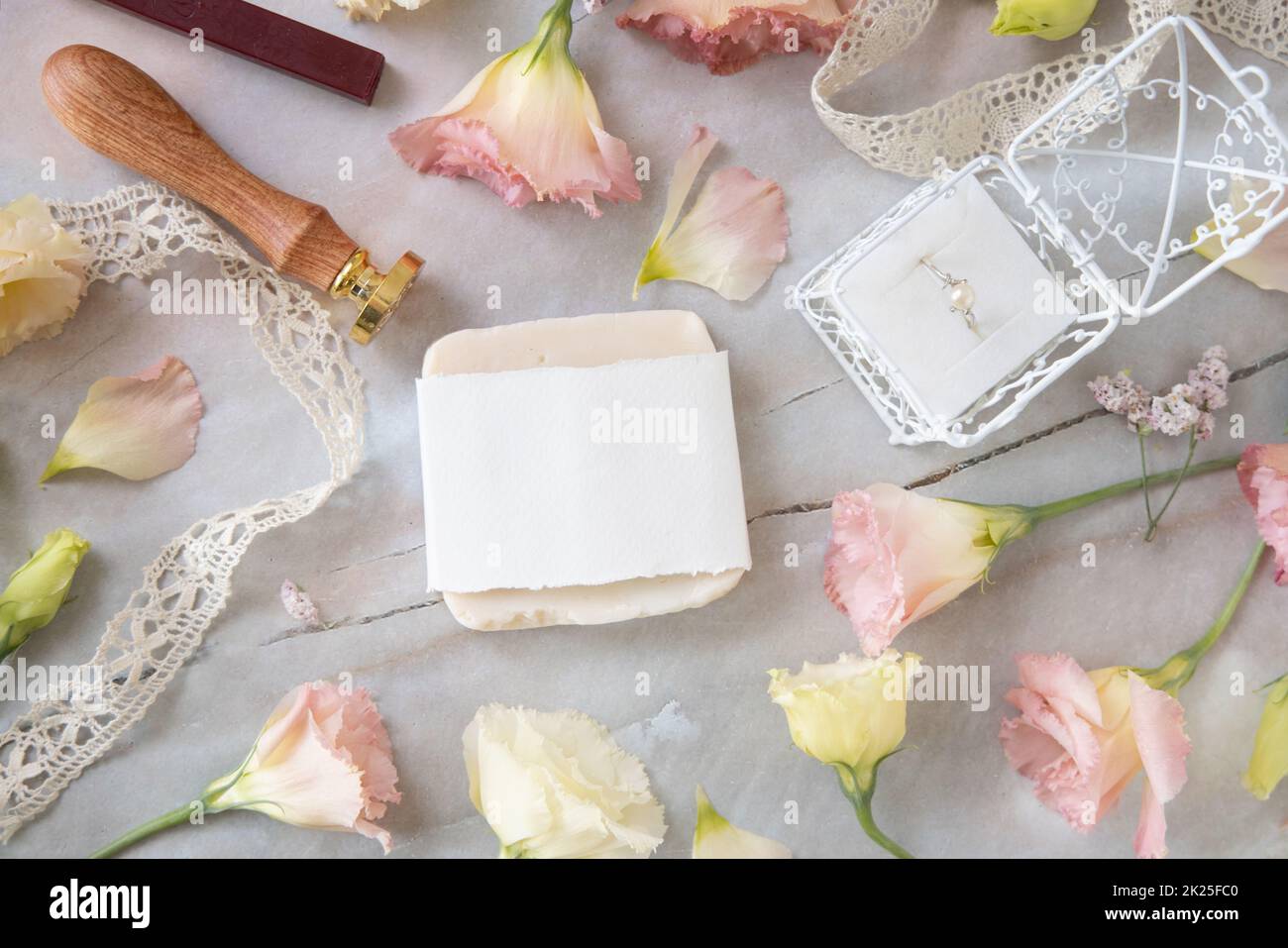 Saponetta su un tavolo di marmo vicino a fiori rosa Foto Stock