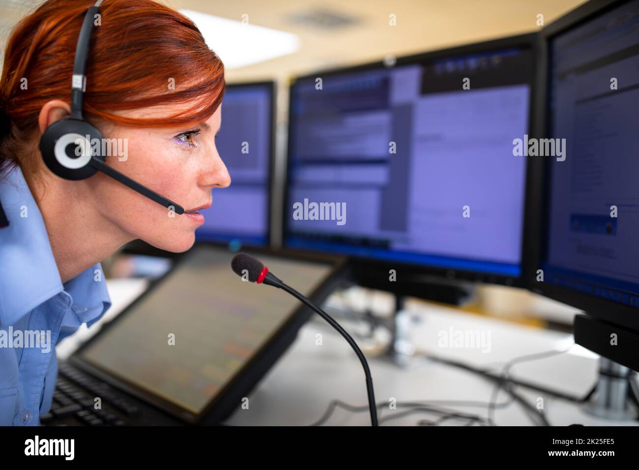 Il dipendente del call center comunica tramite telefono utilizzando un microfono esterno per una migliore ergonomia e sounf Foto Stock
