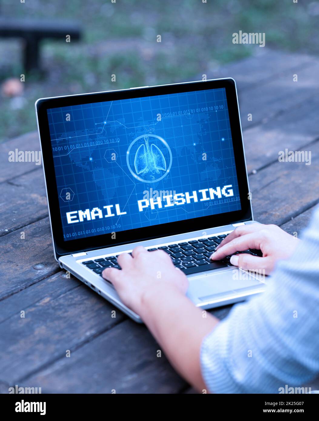Firma di scrittura a mano e-mail phishing. E-mail aziendali che possono collegarsi a siti Web che distribuiscono malware laptop appoggiato sul tavolo che lavora nel Parco che svolge lavori remoti. Foto Stock