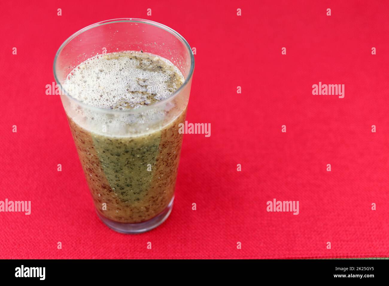 Semi di frutta di Papaya mescolati, polpa e acqua in un bicchiere da bere Foto Stock
