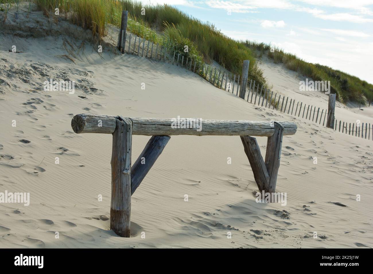 Cancello di legno sulla spiaggia di sabbia di fronte alle dune Foto Stock