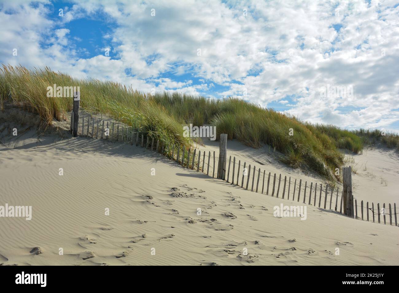 Duna di sabbia con erba spiaggia e recinzione di legno Foto Stock