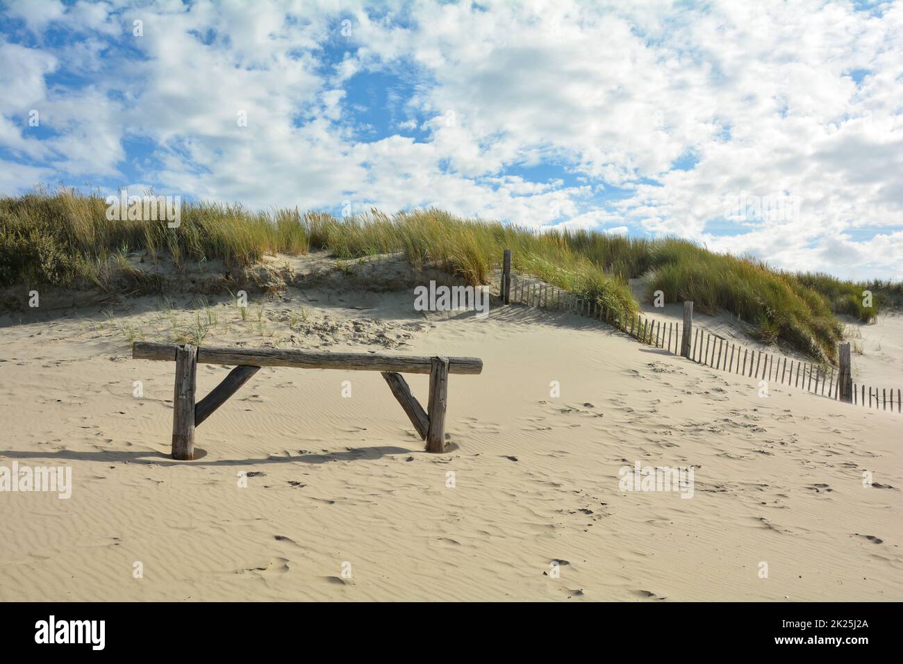 Duna di sabbia con erba spiaggia e una recinzione di legno Foto Stock