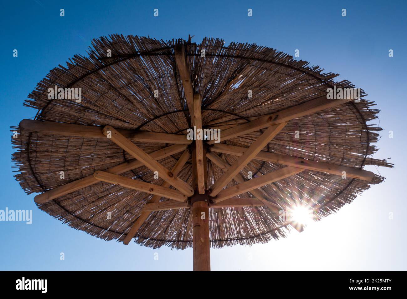 Vista sul bellissimo cielo blu e sull'ombrellone di paglia Foto Stock