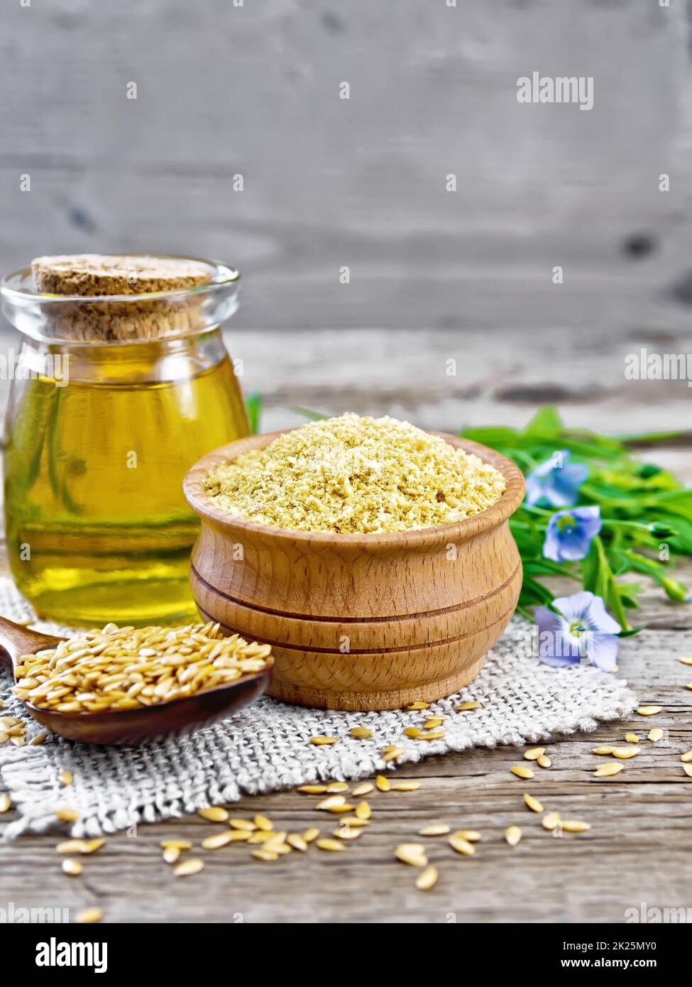 Bran semi di lino in una ciotola con olio in vaso sulla vecchia tavola Foto Stock
