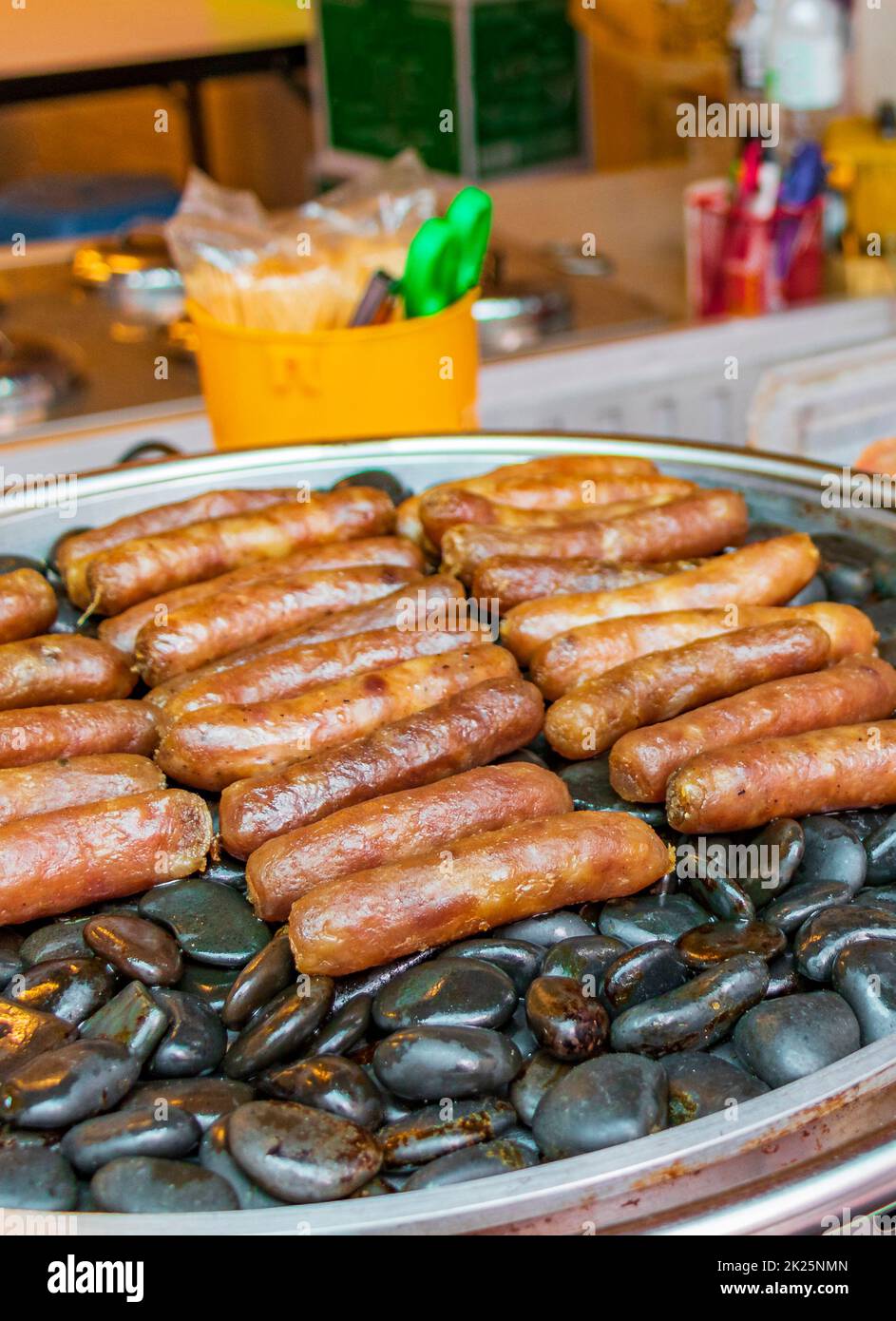 Salsicce alla griglia su pietre calde mercato tailandese China Town Bangkok. Foto Stock