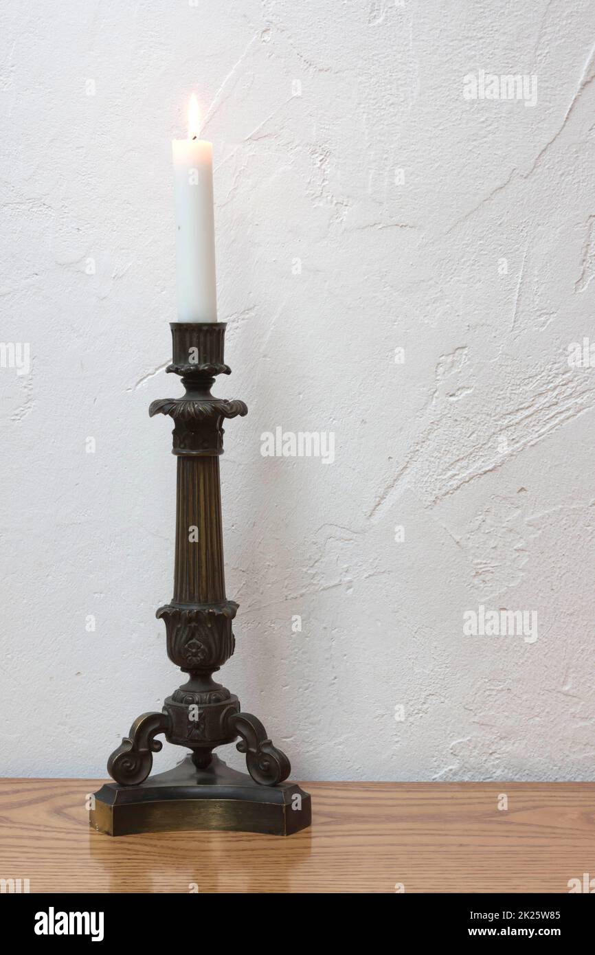 Kerze mit antikem bronzenen Kerzenhalter Foto Stock