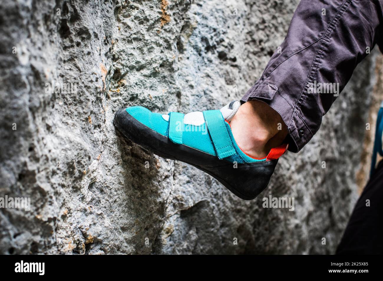 Persona che arrampica mentre indossa le scarpe da arrampicata Foto Stock