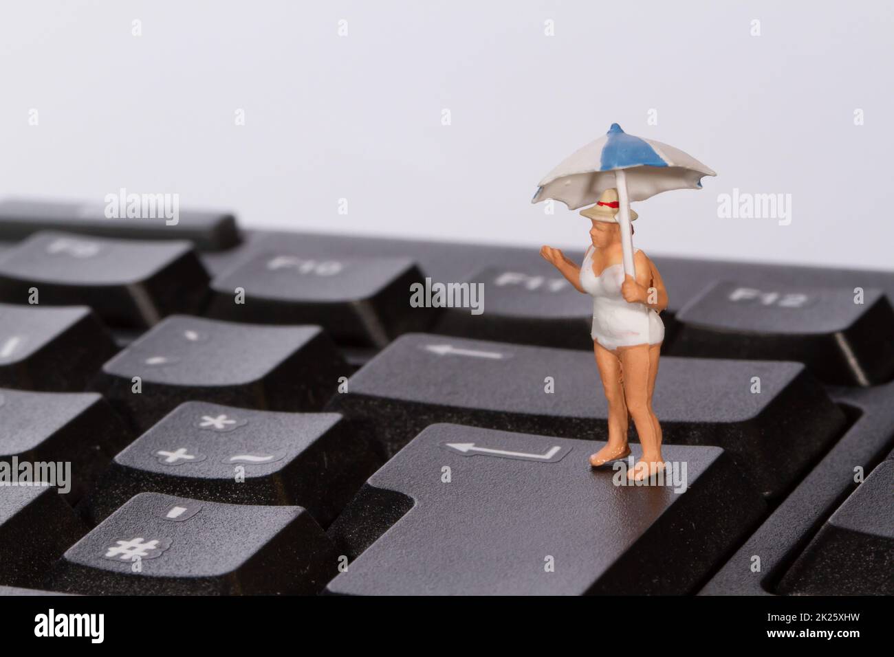 Una figura in un costume da bagno simboleggia una prenotazione di vacanza Foto Stock