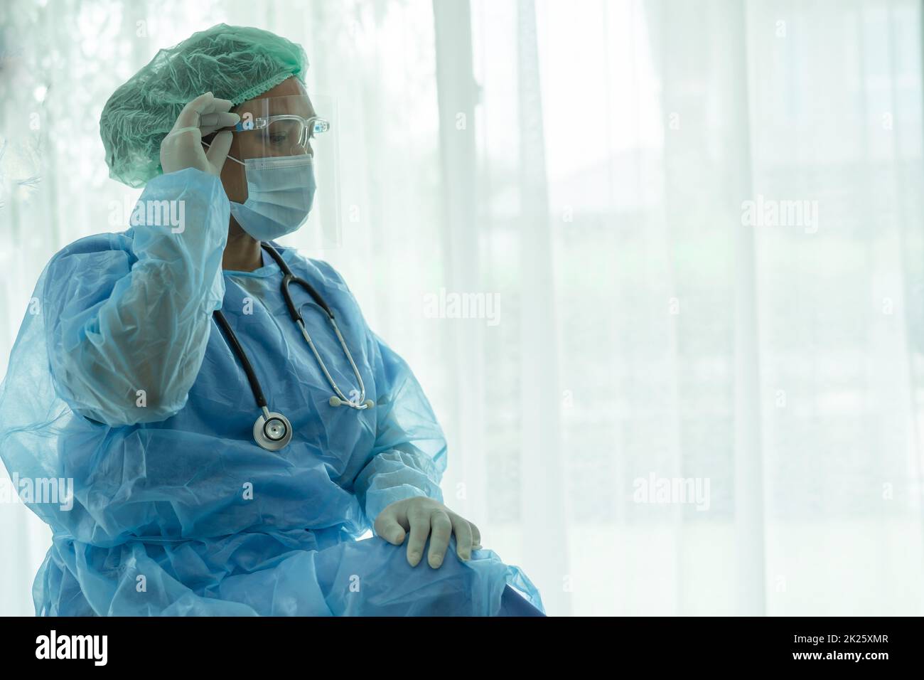 Medico asiatico indossare visiera e PPE tuta nuovo normale per controllare il paziente proteggere l'infezione di sicurezza Covid 19 Coronavirus focolaio in quarantena ospedale reparto infermieristico. Foto Stock