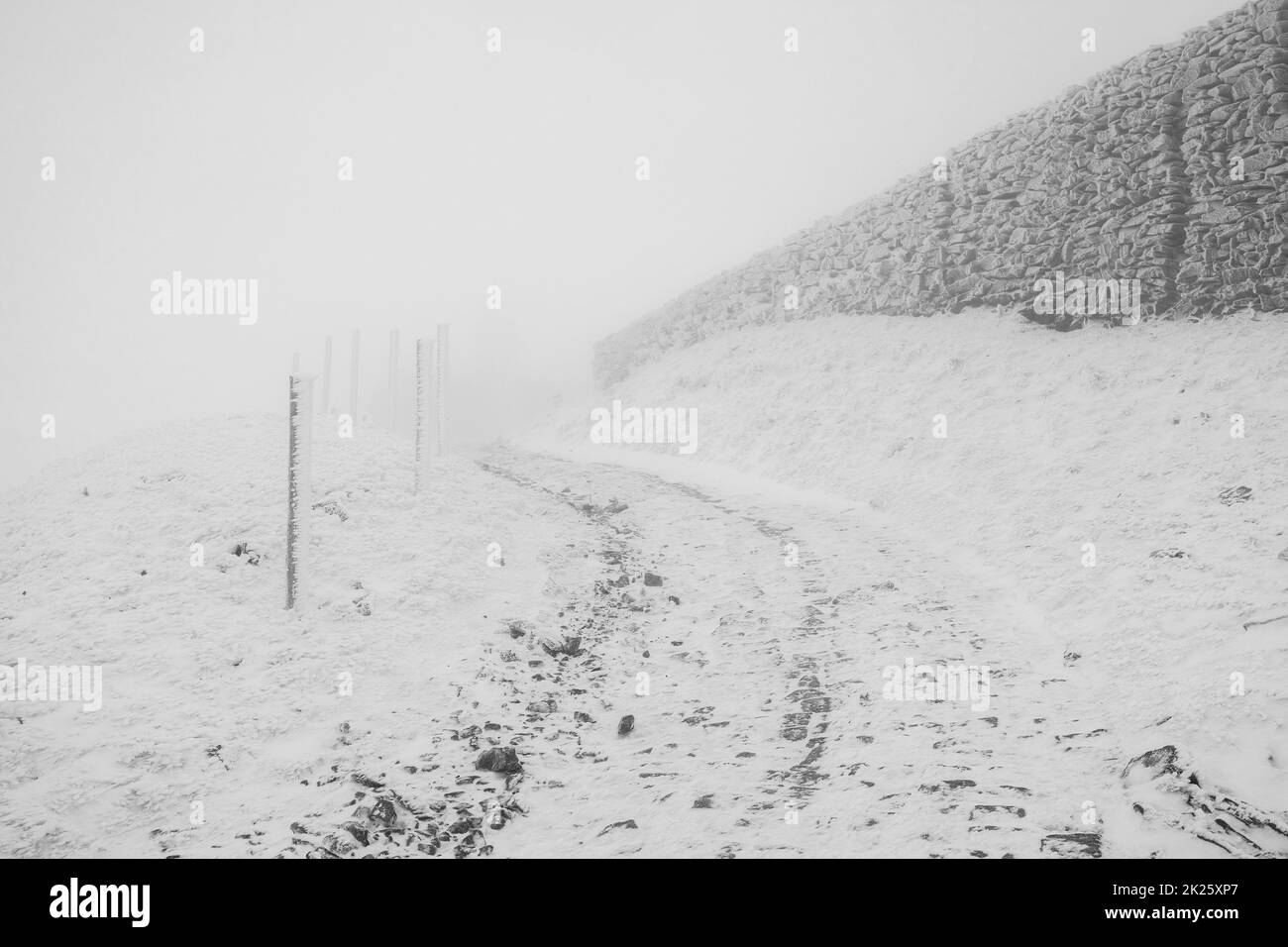 Strada invernale in salita in cattive condizioni meteorologiche. Paesaggio invernale. Foto Stock