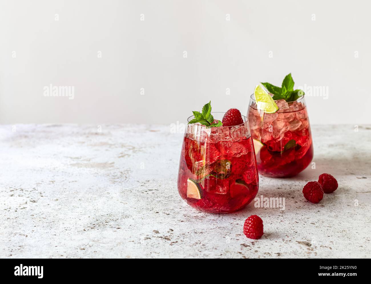 Limonata estiva fresca con lampone, calce, acqua soda e ghiaccio in bicchieri. Foto Stock