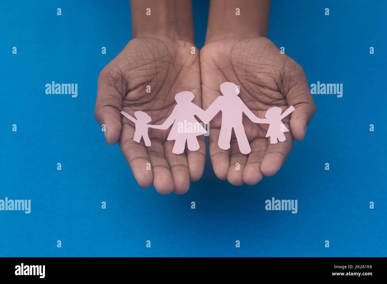 Vista dall'alto dell'intaglio della famiglia con presa a mano. Giornata mondiale della salute protezione contro la violenza domestica, l'assistenza sanitaria e il background medico. Promuovere l'assistenza, il sostegno ai senzatetto e il concetto di allontanamento sociale. Foto Stock