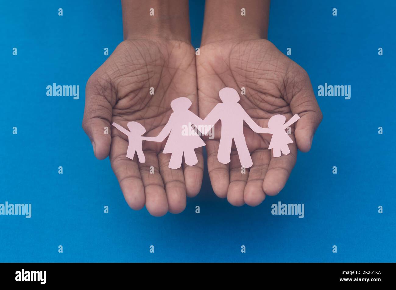 Vista dall'alto dell'intaglio della famiglia con presa a mano. Giornata mondiale della salute protezione contro la violenza domestica, l'assistenza sanitaria e il background medico. Promuovere l'assistenza, il sostegno ai senzatetto e il concetto di allontanamento sociale. Foto Stock
