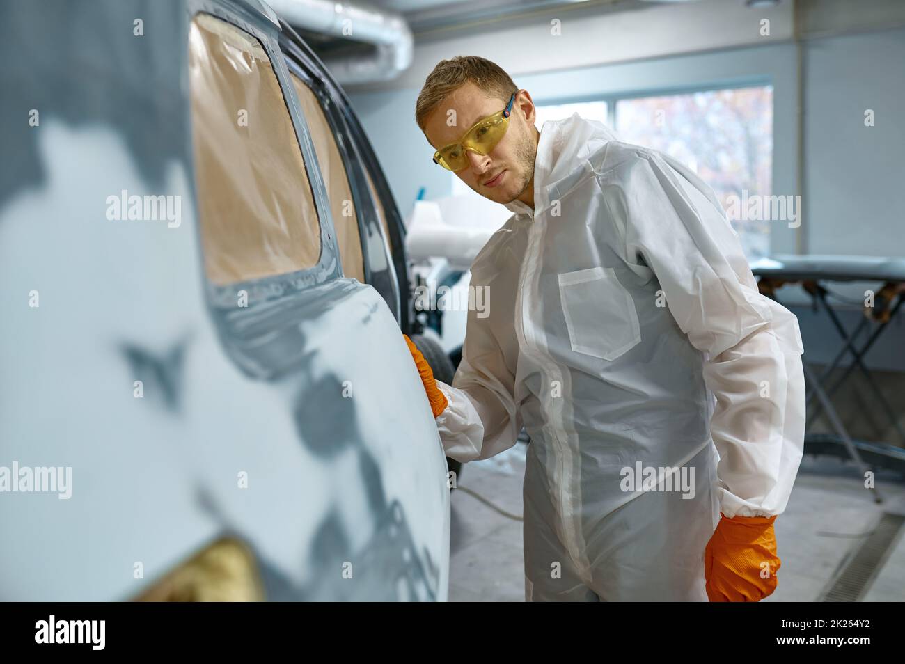 Il personale addetto alla riparazione controlla la qualità della vecchia rimozione della vernice Foto Stock