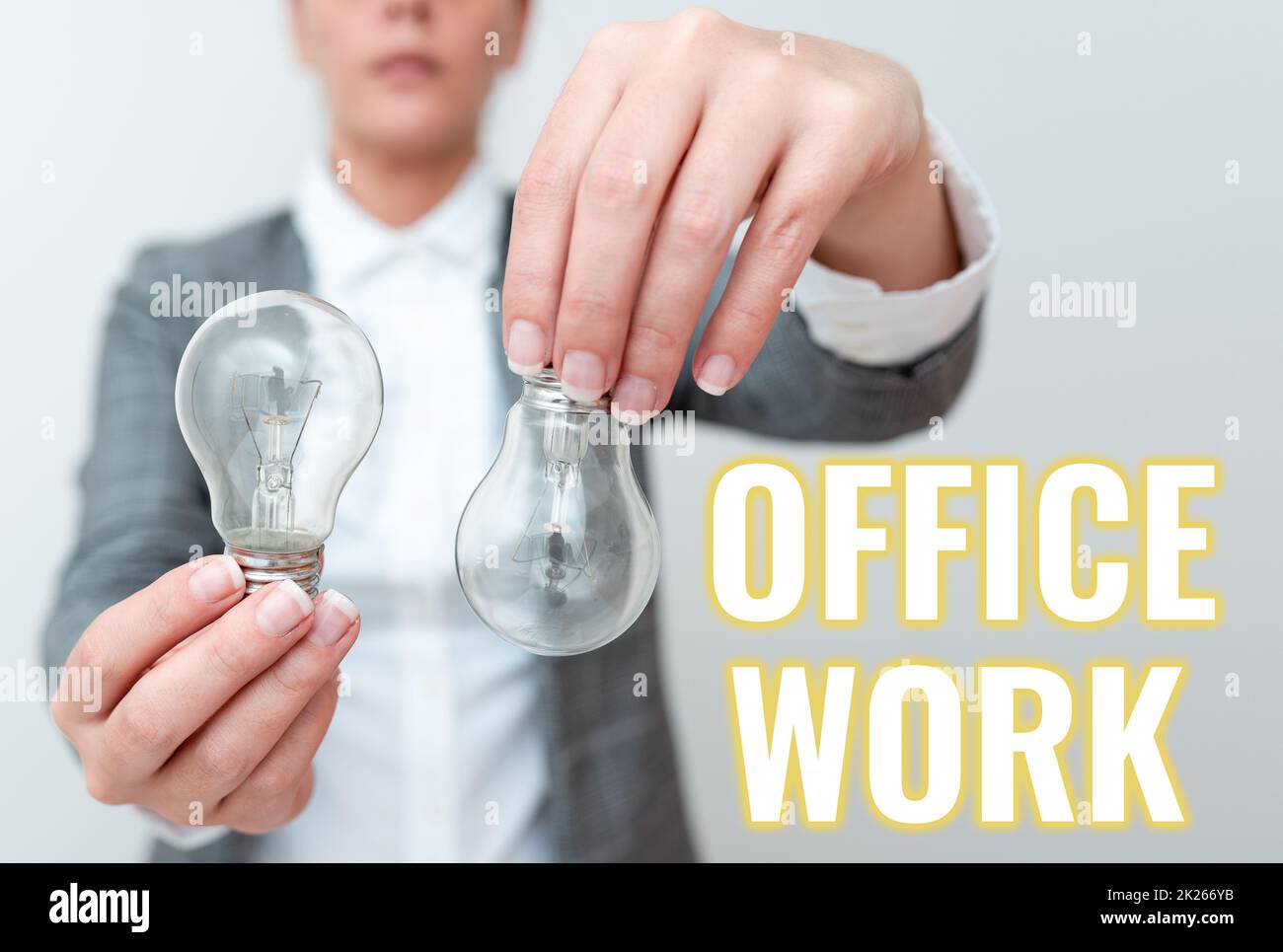 Scrittura a mano segno Ufficio lavoro. Business Concept un lavoro che avviene principalmente nell'ambiente d'ufficio vestito da donna che tiene due lampade capovolte presentando nuove idee tecnologiche Foto Stock