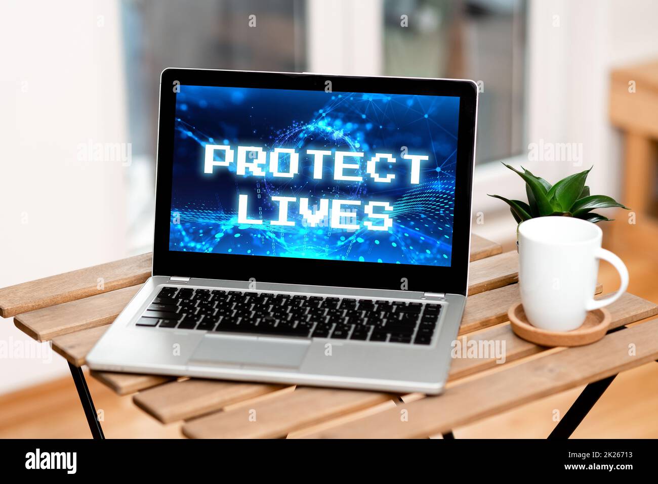 Didascalia di testo che presenta Protect Lives. Panoramica aziendale per coprire o proteggere da danni o distruzioni dovuti a lesioni da esposizione laptop appoggiato su Un tavolo accanto alla tazza del caffè e all'impianto che mostra il processo di lavoro. Foto Stock