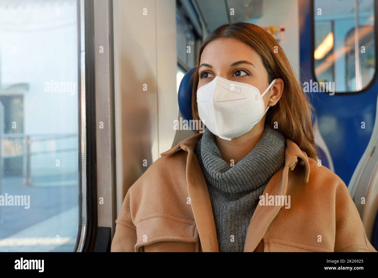 Donna d'affari che indossa una maschera protettiva mentre viaggia con i mezzi pubblici Foto Stock
