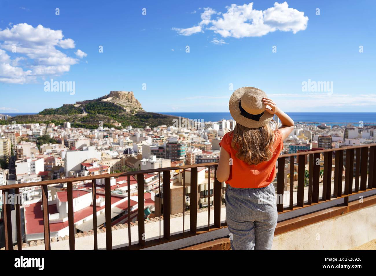 Ragazza viaggiante che gode di vista del paesaggio urbano di Alicante e del Monte Benacantil con il Castello di Santa Barbara e il mare sullo sfondo, Spagna Foto Stock