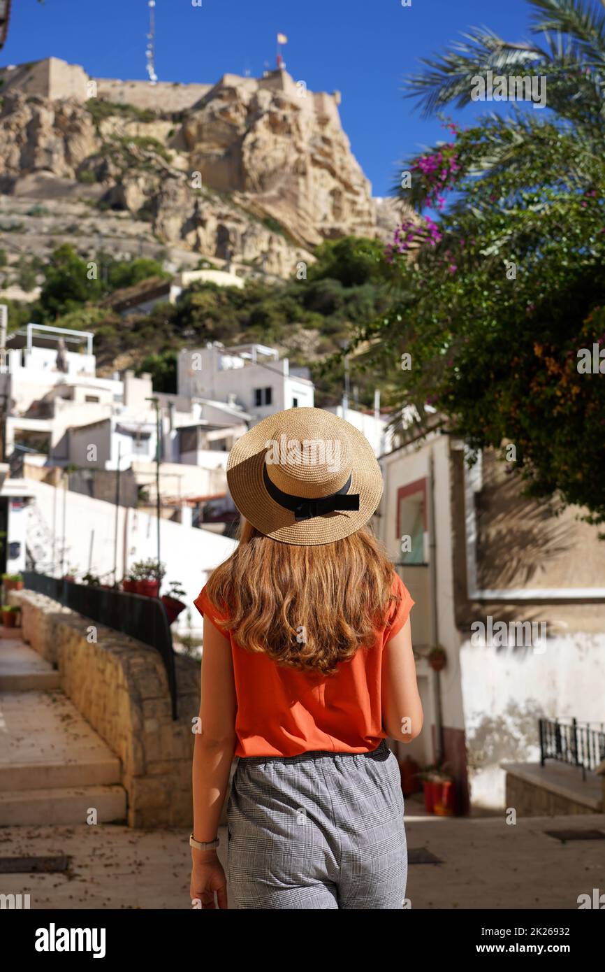 Donna turistica che cammina nel quartiere di Santa Cruz guardando il Monte Benacantil con il castello di Santa Barbara in Alicante, Spagna Foto Stock