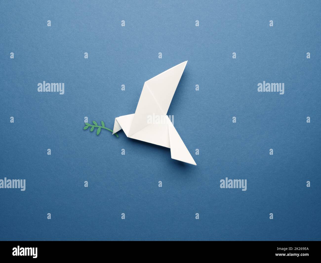 Piccione origami bianco su sfondo di carta blu Foto Stock