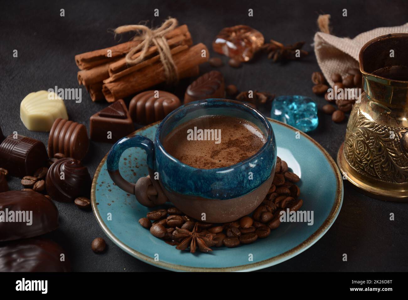 Tazza di caffè, fagioli, cioccolato su vecchio tavolo da cucina assortimento di dolci al cioccolato fondente, bianco e latte, zefiro (zephyr). Spezie, cannella. Foto Stock