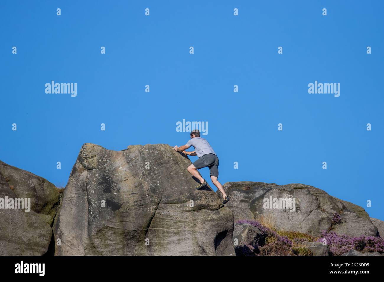 Man bouldering al Cow and Calf Rocks a Ilkley Quarry, Ilkley Moor, West Yorkshire, Inghilterra, Regno Unito Foto Stock