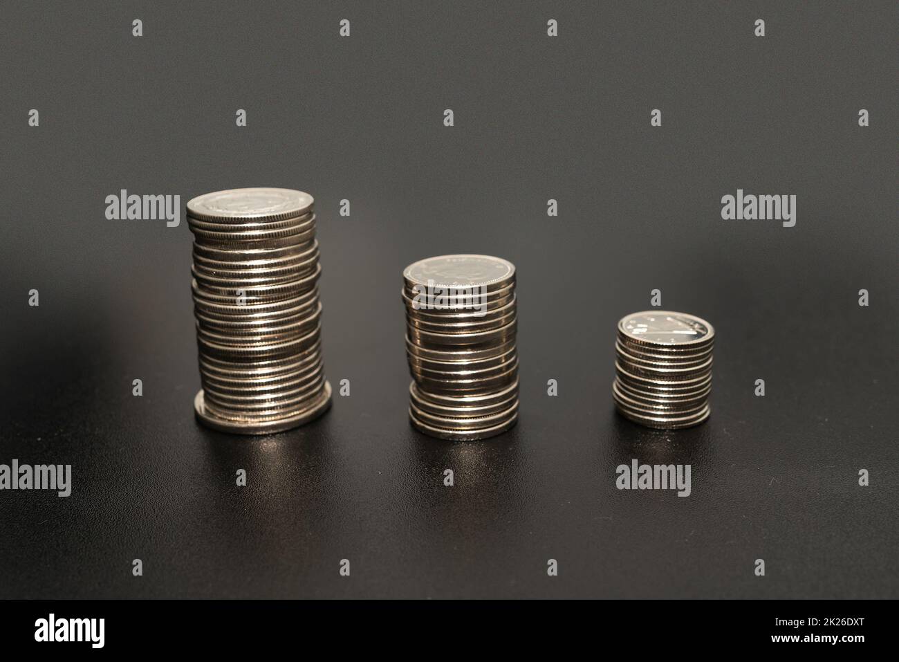 Coins pile sopra la tabella che presenta i piani finanziari. Piani ipotecari per la casa e l'ufficio utilizzando i soldi. Foto Stock