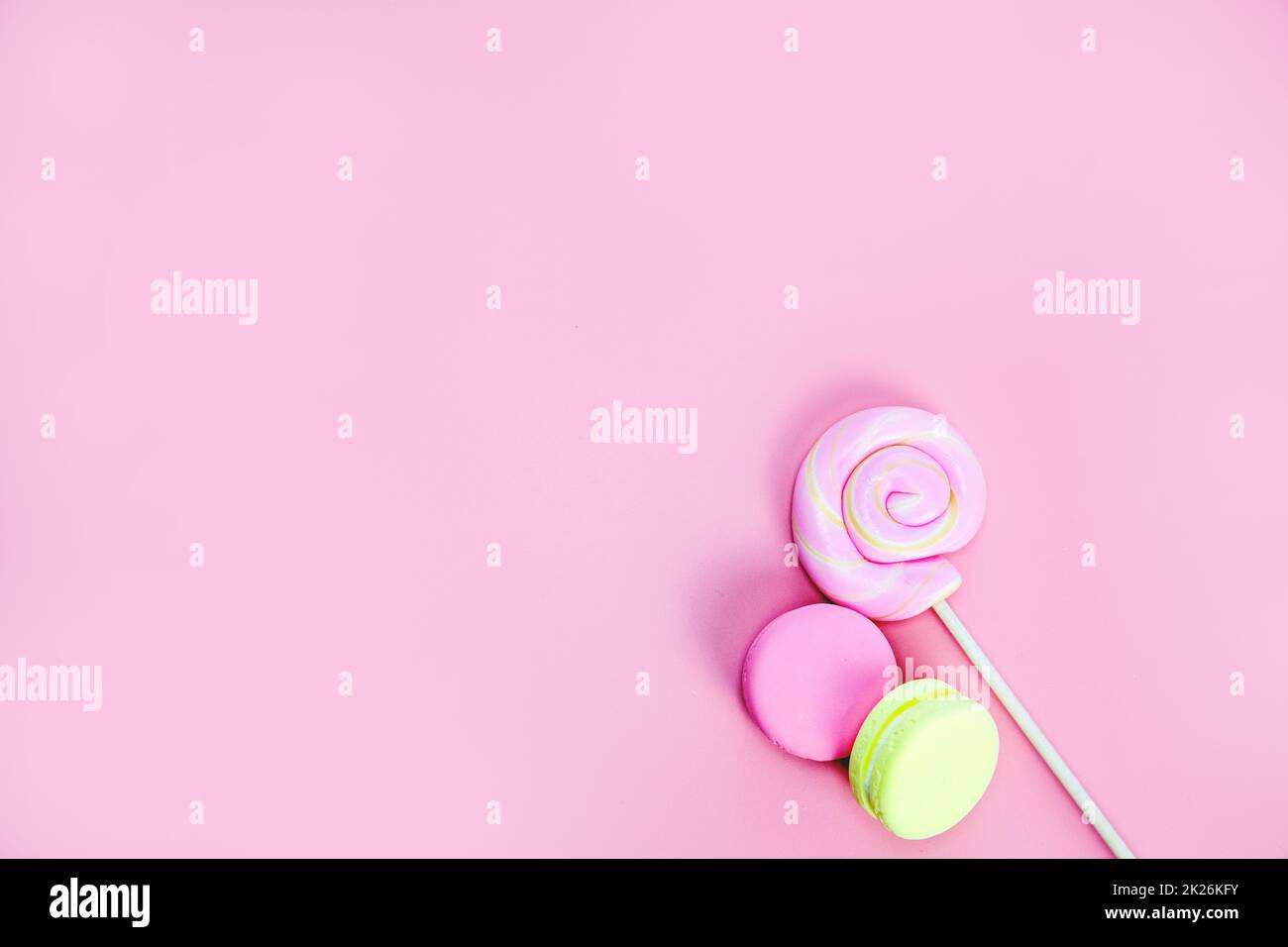 Dolce caramelle concetto. Lecca e ciambelle rosa, macaron su sfondo rosa, vista dall'alto dello spazio di copia Foto Stock