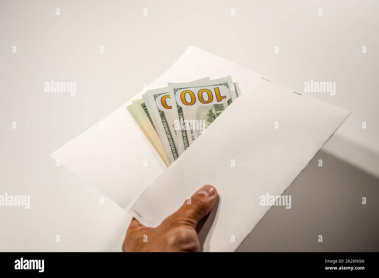 Dollari in un conwind su sfondo bianco, un sacco di soldi in una busta. Foto Stock