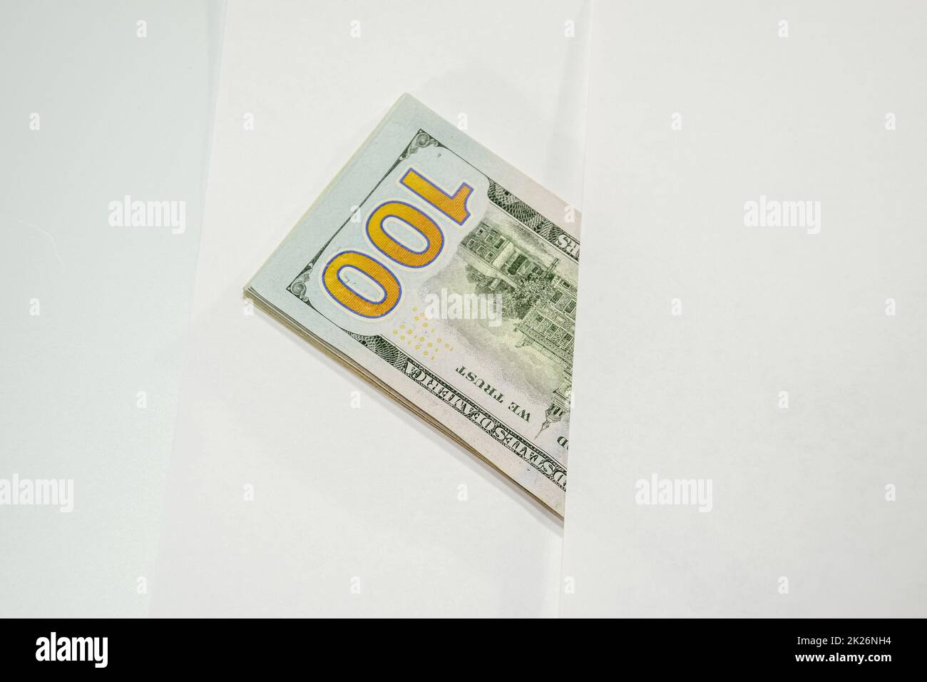 Dollari in un conwind su sfondo bianco, un sacco di soldi in una busta. Foto Stock
