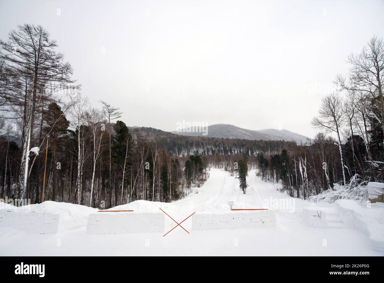 Le aree sciistiche e per lo snowboard sono circondate da splendidi paesaggi nella stagione invernale. C'è uno ski-pole che blocca la strada verso il basso perché non è ancora aperto per il servizio. Foto Stock
