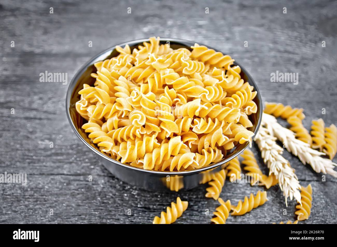 Fusilli grano intero in ciotola su tavola scura Foto Stock