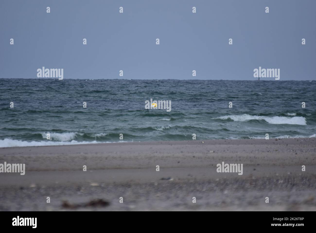 Diversi fuochi di una spiaggia contro l'oceano con un piccolo boa galleggiante Foto Stock