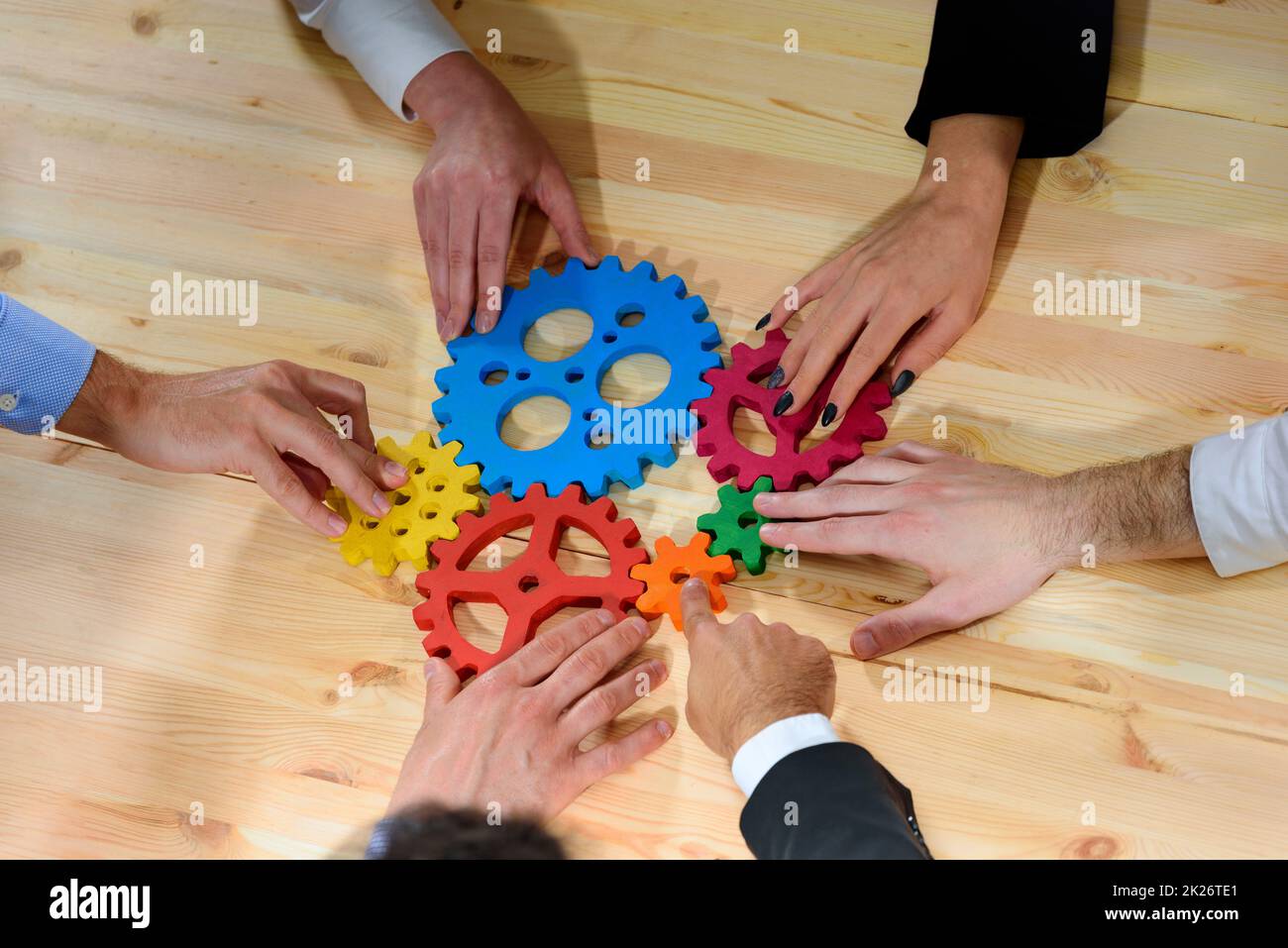 Il team aziendale collega componenti di ingranaggi come un lavoro di squadra e partner Foto Stock
