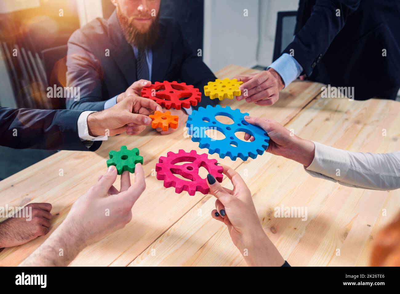 Il team aziendale collega componenti di ingranaggi come un lavoro di squadra e partner Foto Stock