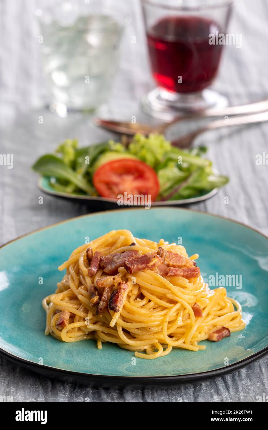 spaghetti alla carbonara su un piatto blu Foto Stock