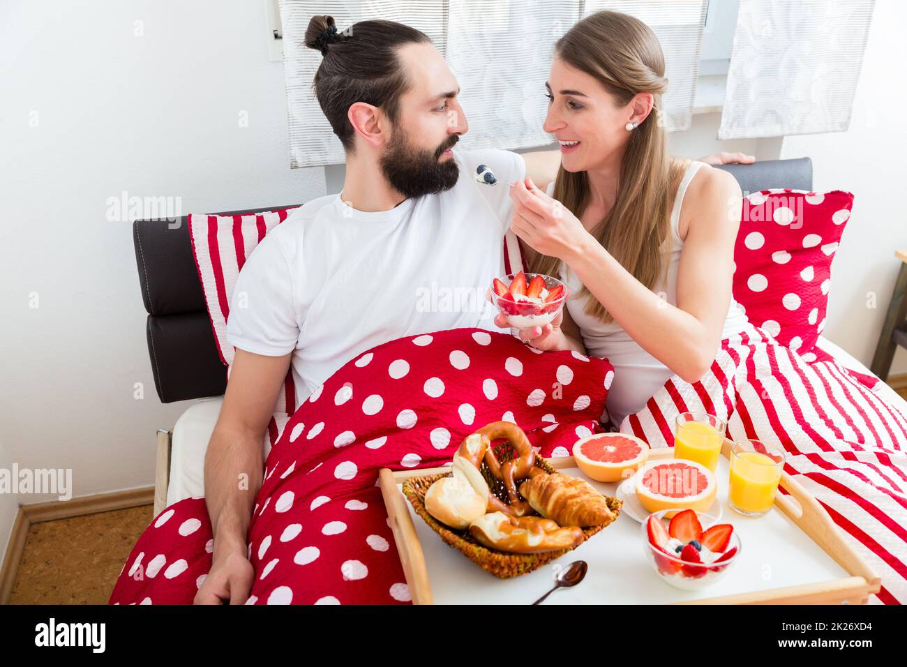 Coppia giovane avente la colazione a letto Foto Stock