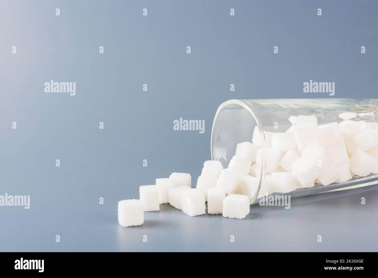 cubetti di zucchero ingrediente alimentare dolce versato dal bicchiere Foto Stock